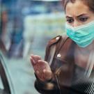 Masked woman looks at empty food display in grocery store