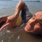 Photo: Swimming man holding lip of giant fish