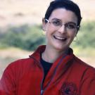 Female scientist in red jacket.