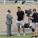 Chancellor Gary S. May speaks to Keelan Doss as a film crew records their conversation.