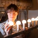 Woman installs an LED bulb. 