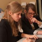 Female student at a computer getting advice from a woman next to her