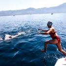 Swimmer jumps off boat.