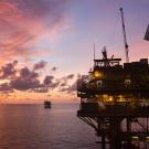 An offshore oil rig at sunset