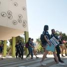 Orientation leaders walk by a residence hall