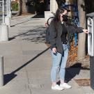 Woman uses parking kiosk.