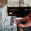 Photo: Man playing piano on Wyatt Deck, amid Folk Music Jam Session.