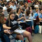 Student with hand raised in lecture