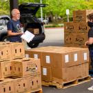 Robb Davis stands near boxes of food and a volunteer.