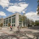 Students ride bicycles past Shields Library.