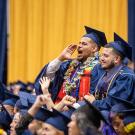 Two male students standing among others at graduation