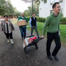 Employees carrying food and gifts to Justin Lok's car.