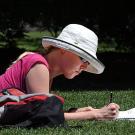 A female student studies on the Quad