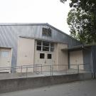 Low, one-storied metal building with cement ramp leading to doors.