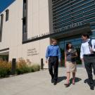 Photo: Three people in business attire exit the Graduate School of Management