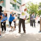 Provost Ralph J. Hexter and others stretch before a UC Walks event at UC Davis.