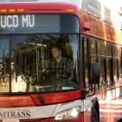 Unitrans bus, shot from the front, looking in at the driver.