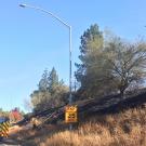 A fire truck next to a burned hillside.