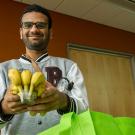 A male student holds a bunch of bananas