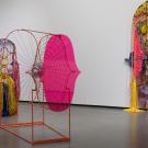 Gallery with three colorful textile and wire sculptures against white walls