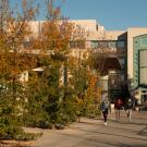 Student walk the promenade between the Student Community Center and the Library that run in front of the Graduate Center.