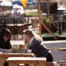 Two students talk, work, and eat at G Street and 3rd Street on January 31, 2022. 