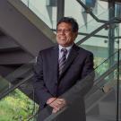 Prasant Mohapatra stands on a staircase with an outdoor view in the background. 