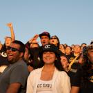 The crowd of Aggies, wearing UC Davis merchandise, cheers on their team during the Homecoming football game between UC Davis and Northern Arizona in the glow of the sunset.