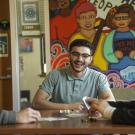 Three students laughing and hanging out while playing Lotería in one of the Cross Cultural Center’s many common areas.