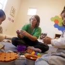 2 kids playing with a teacher with toys