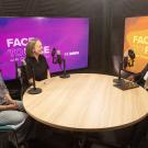 Studio podcast with three people at round table, mics, purple and orange backdrops