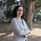 Female professor, head and upper body shot outside with arms folded