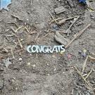 A "congrats" plastic cutout litters the ground