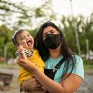 baby and masked mother in park setting