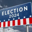 Red, white and blue sign that says "election" with blue sky behind 