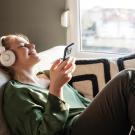 Woman sitting on couch listening to earphones
