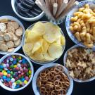 In this episode of Unfold, we uncover the science and debate behind processed and ultra-processed foods. Shown here are seven bowls with various processed and ultra-processed foods, including chips, pretzels and candies.(Getty)