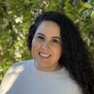 A closeup of Lizbeth Lopez with greenery in the background