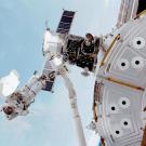 An astronaut making a spacewalk outside a space station. 