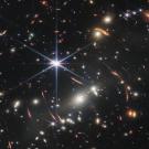 Hundreds of stars and galaxies against a black background