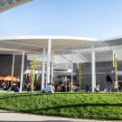 Crowds on lawn in front of white museum with see-through roof