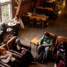 Students sitting in leather chairs and at tables, engaged in conversation or using laptops at the Silo.