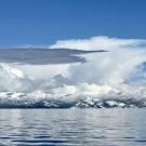 Lake Tahoe with snow-capped mountains in background under winter clouds