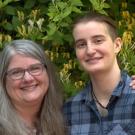 Teresa and Anna Skarr pose together in front of a bush at UC Davis. 