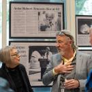 Three people stand in front of library exhibit on Robert Arneson