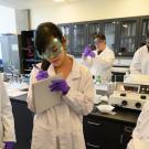 Students in goggles confer in a lab at UC Davis. 
