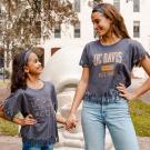 Young girl and teen pose for photo next to UC Davis Egghead sculpture.