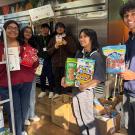 People hold up nonperishable food items in the ASUCD Pantry