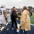 Sacramento State President Luke Wood and UC Davis Chancellor Gary S. May shake hands on the football field.