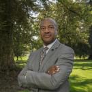 Chancellor Gary S. May, arms folded, on the Quad